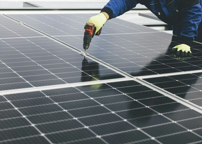Gloved hands fitting a solar module